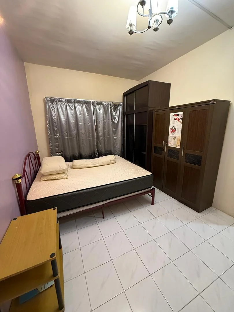 Bedroom features: queen-size bed, mattress on bed frame, wooden wardrobe with sliding doors, curtains in grey, chandelier light fixture, white tiled flooring, painted walls in cream, wooden bedside table.